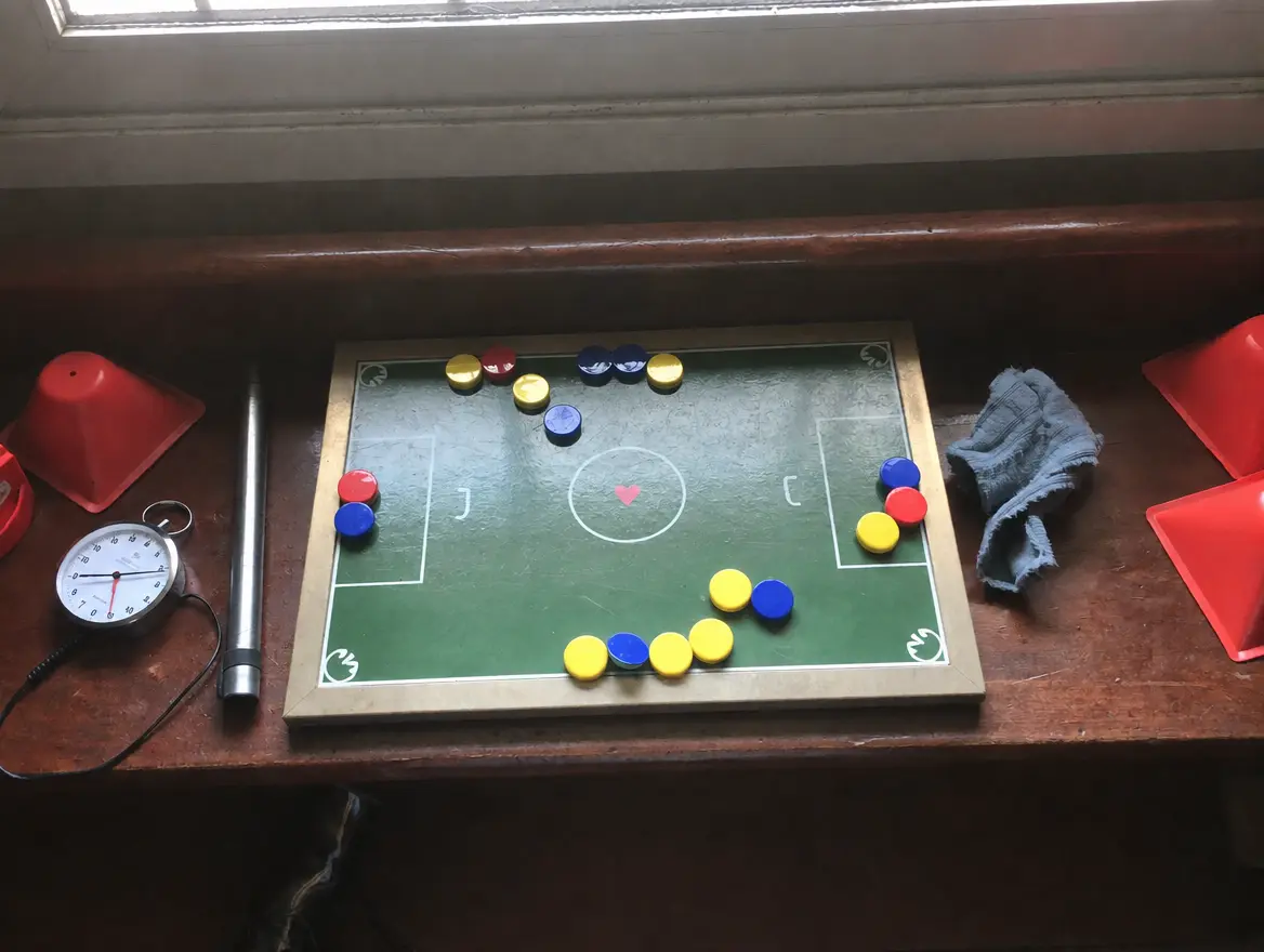 Un tableau tactique magnétique, un sifflet et un chronomètre posés sur le banc du vestiaire